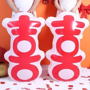Detail of large pink and red double happiness foil balloons held by models for wedding decor