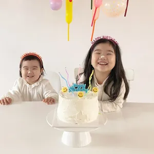 Kids birthday party accessories featuring colorful Happy Birthday headbands and cake toppers