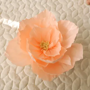 Macro detail of large handmade apricot crepe paper flower with ruffled petals and center stamen