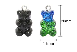 Detailed view of 20mm resin gummy bear charms in solid black and teal glitter gradient