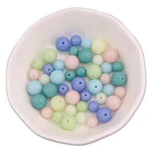 Luminous glass beads in macaron colors with matte finish for DIY jewelry in a ceramic bowl