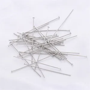 Macro view of silver flat head pins for handmade jewelry DIY accessories on white fabric