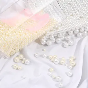 Mix of round white faux pearls on silk fabric with pink feathers for DIY jewelry making