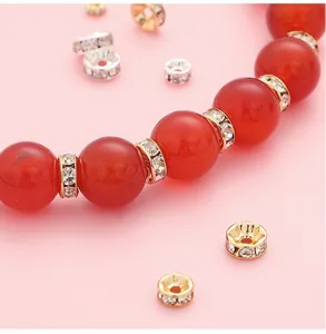 Macro detail of 14K gold plated rhinestone spacers and red beads for DIY jewelry making