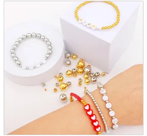 Detail of DIY bracelets with metallic CCB beads and heart links on a white stand
