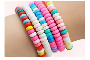 Primo piano di braccialetti colorati in perline heishi in pasta polimerica sul polso