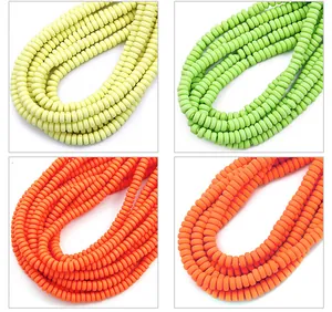 Dettaglio di perline piatte in argilla colorata gialla, verde e arancione per gioielli fai-da-te