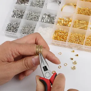 Primo piano di pinze che lavorano anelli di metallo con un kit per gioielli fai-da-te