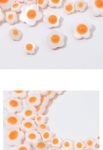 Macro detail of white and orange daisy resin beads for DIY jewelry and crafts making