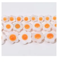 Macro shot of white shell flower beads with orange centers for DIY jewelry making
