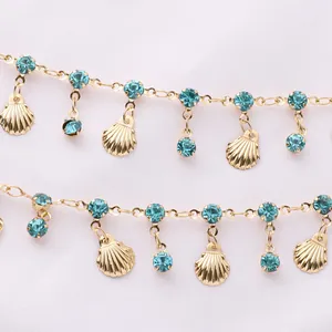 Close-up of golden copper chain with sky blue rhinestones and shell pendants detail
