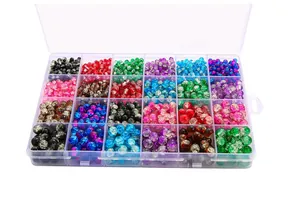 Détail macro d'une boîte de 24 cases remplie de perles de verre craquelées pour loisirs créatifs