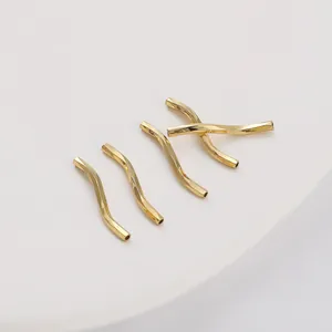 Macro detail of 14K gold plated curved S-tube beads for DIY jewelry making