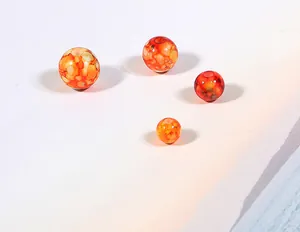 Vue détaillée de quatre perles en acrylique à motif marbré pour la création de bijoux DIY