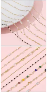 Detailed view of 14k gold plated chains with pearls, colorful beads and geometric charms