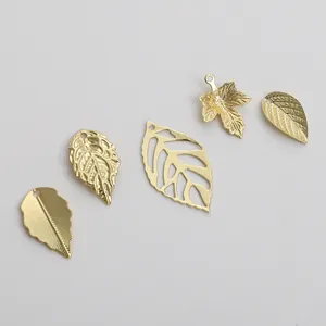 Detail view of 14K gold plated hollow leaf charms with intricate engraved textures for DIY jewelry