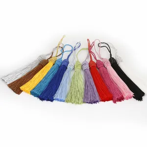 Détail de 13 pompons colorés en polyester avec des nœuds tissés décoratifs