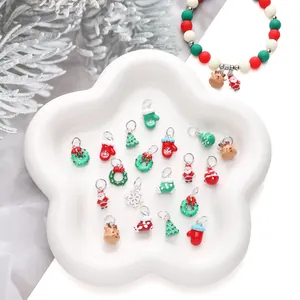 Detailed view of alloy Christmas charms with Santa and reindeer motifs in a ceramic tray