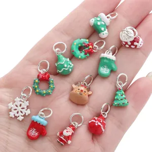 Assorted Christmas alloy enamel charms held in hand for DIY jewelry making and crafts