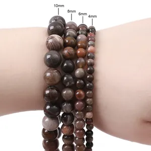 Natural round stone beads for DIY bracelets showing 4mm to 10mm size variations on wrist
