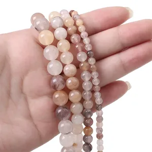 Natural round sunstone beads for jewelry making shown in four sizes on hand