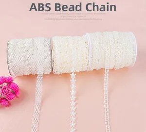 Detailed macro view of white ABS pearl chain with floral and double-row beaded patterns