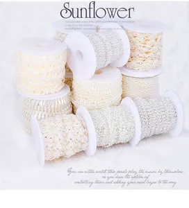 Close-up of pearl and rhinestone lace ribbons on white spools for DIY wedding crafts