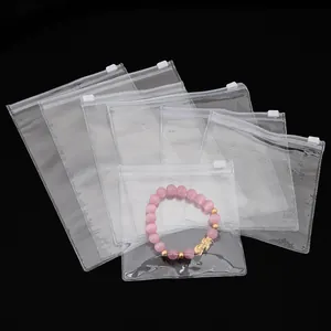 Multiple sizes of clear PVC zipper storage bags for jewelry on a sleek black background