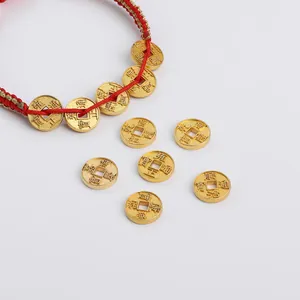 Macro detail of red woven bracelet with gold-plated Chinese Five Emperor coins and lucky charm