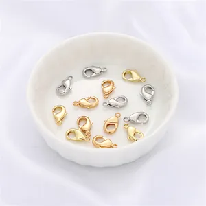 Golden and silver 14K gold-plated lobster clasps for DIY jewelry making in a white dish