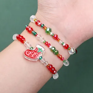 Three-piece Christmas beaded bracelet set with red and green faceted beads and stocking charm