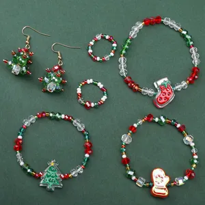 Detailed flat lay of Christmas jewelry set with tree and sock charms on green background