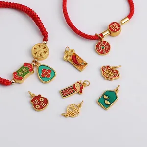 Detail of red braided cord bracelets with gold-plated Chinese lucky charms and pendants