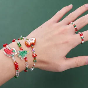 Christmas beaded jewelry set with red and green bracelets and rings on a hand
