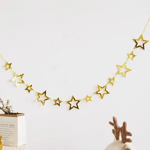 Detail of hanging gold mirror star garland decoration on a clean white wall background