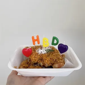 Colorful HBD letter and heart birthday cake candles set on a white dessert tray