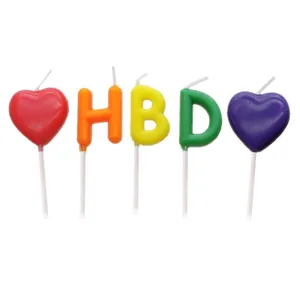 Colorful HBD letter and heart-shaped birthday cake candles set on white background