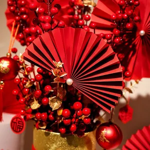 Chinese New Year decoration kit with red paper fans, golden leaves, and red berries