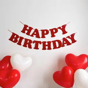 Dettaglio dello striscione rosso Happy Birthday con palloncini a cuore rossi e bianchi