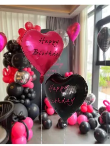 Detail of rose red and black heart-shaped foil balloons with Happy Birthday lettering
