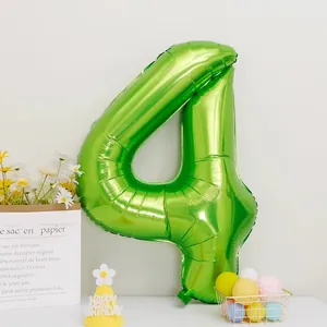 Detail of a large number 4 fruit green foil balloon with a happy birthday party hat
