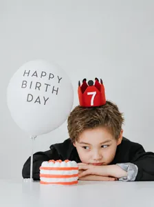 Detalle de corona de fieltro roja número 7 y set de globos de cumpleaños para niños