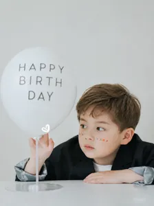 Detalle de una americana negra para niños con forro estampado y globo de cumpleaños