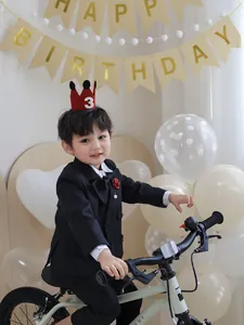 Close-up of baby boy birthday formal suit with red number 3 crown hat and balloons