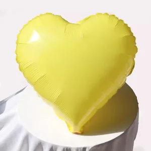 Dettaglio del palloncino a cuore giallo in alluminio con lucentezza su tessuto bianco