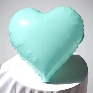 Dettaglio macro di un palloncino in alluminio verde menta a cuore con trama metallica