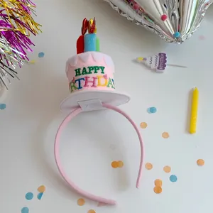 Close-up of pink plush birthday cake headband with candles and colorful confetti background