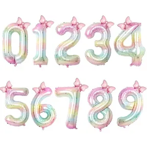 Rainbow gradient number balloons with pink bow and gold stars for birthday party decoration