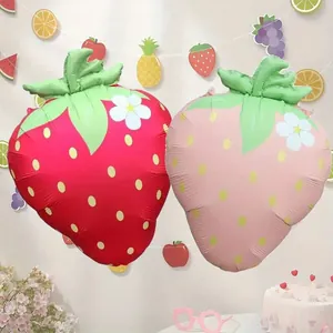 Matte strawberry foil balloons in red and pink for birthday party scene decoration