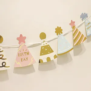 Guirlande d'anniversaire rose et bleue avec lettres dorées et pendentifs de chapeau